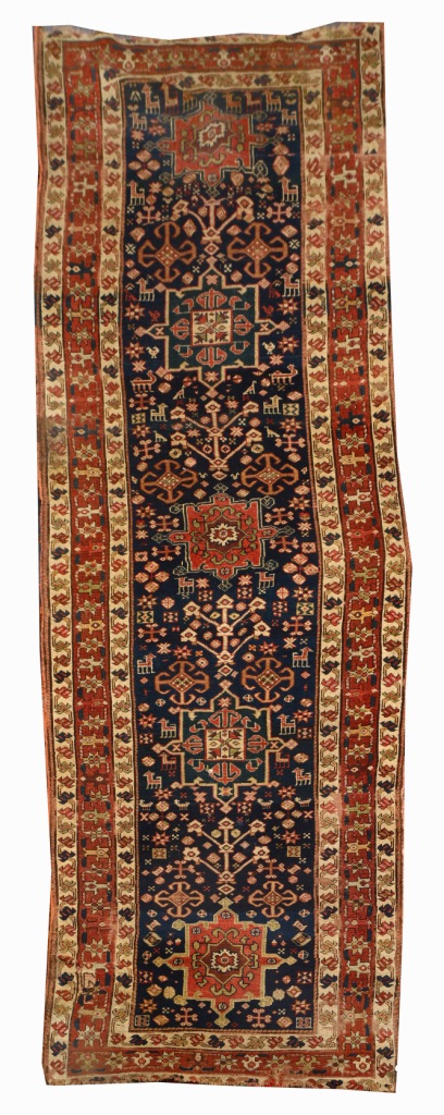 A CAUCASIAN BLUE GROUND RUNNER decorated hooked medallions within a triple foliate border, 3.7m x