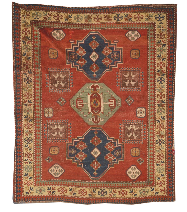 A KASAK RED GROUND RUG decorated a central polychrome interlocking medallion design and four square