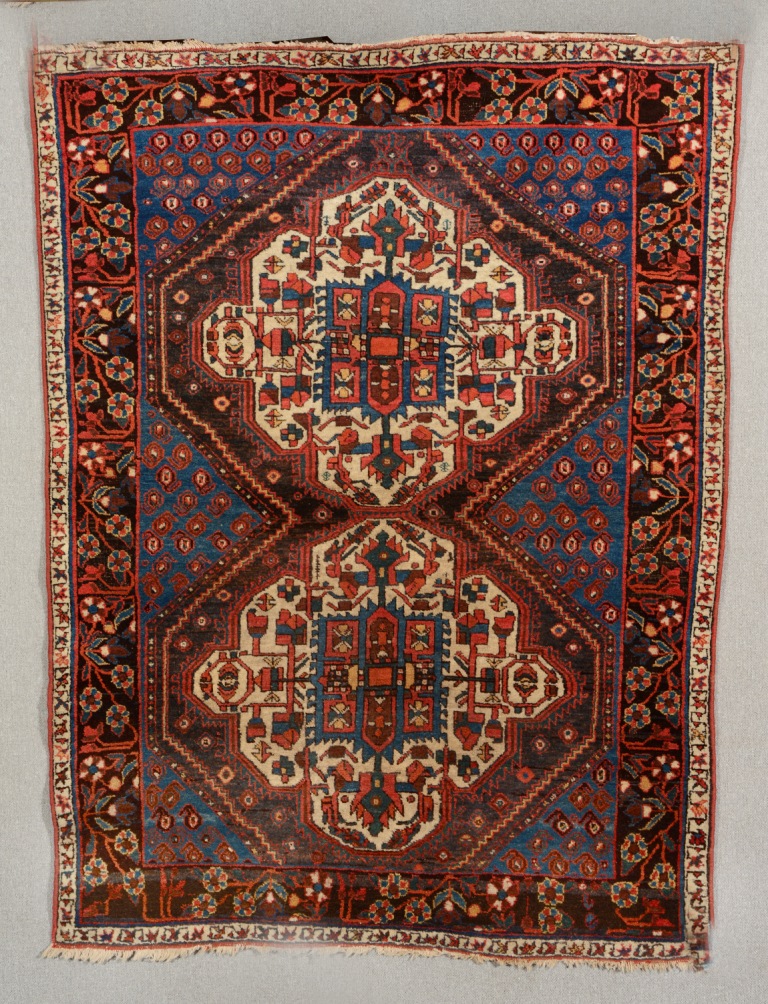 AN OLD AFSHAR RUG with double central medallion within a blue ground field of botehs and trailing
