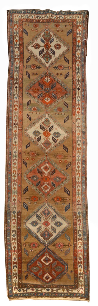A NORTH WEST PERSIAN BROWN GROUND RUNNER with six interlinked medallions within a polychrome triple