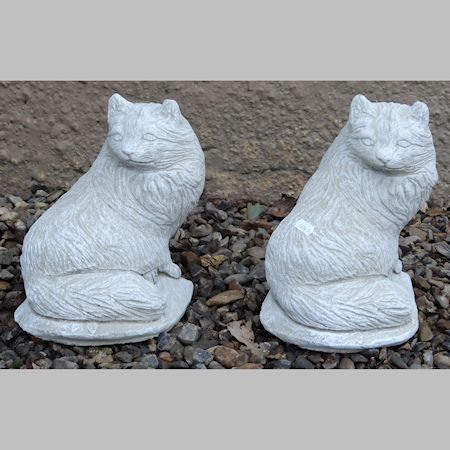 A pair of reconstituted stone figures of cats