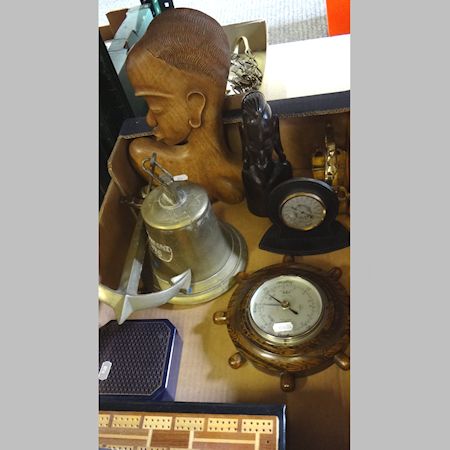 A collection of items to include an African carving, a brass bell and a barometer