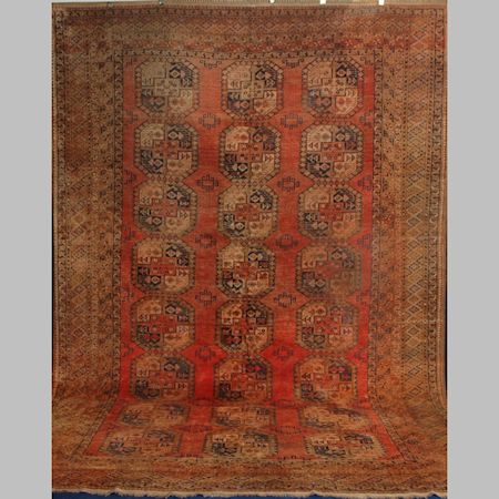 An Afghan carpet, with three rows of central medallions on a red ground, within multiple borders,