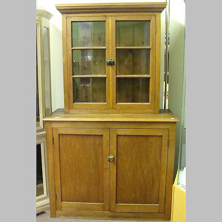 A 20th century pine cabinet, having a glazed upper section with cupboards below