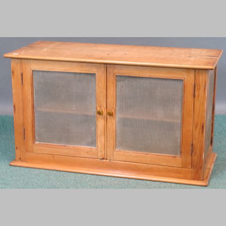 An antique pine food cupboard, enclosed by a pair of doors, 91cm