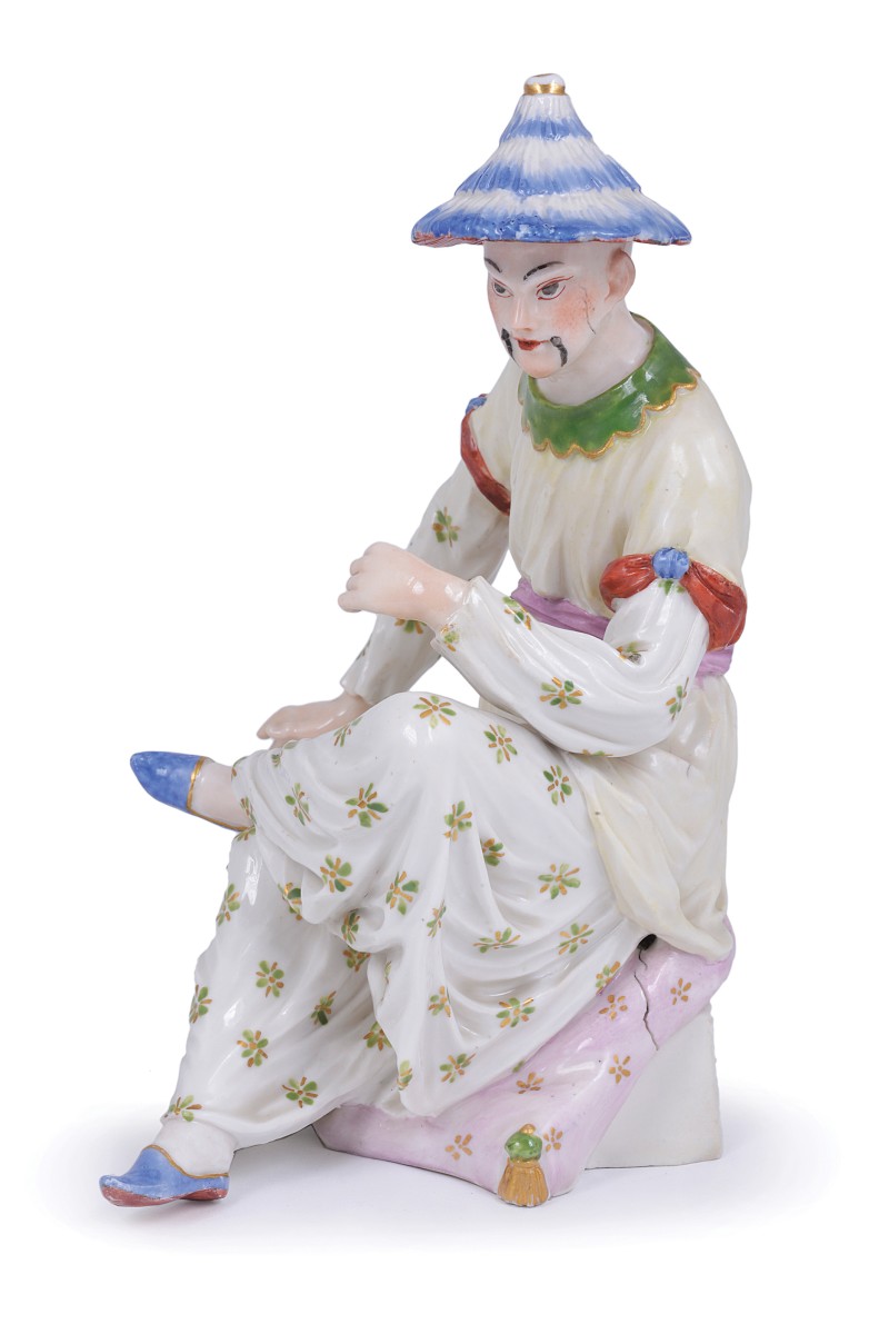 A LUDWIGSBURG FIGURE OF A CHINAMAN, MODELLED BY JOSEPH WEINMÜLLER, CIRCA 1767 shown seated on a pink