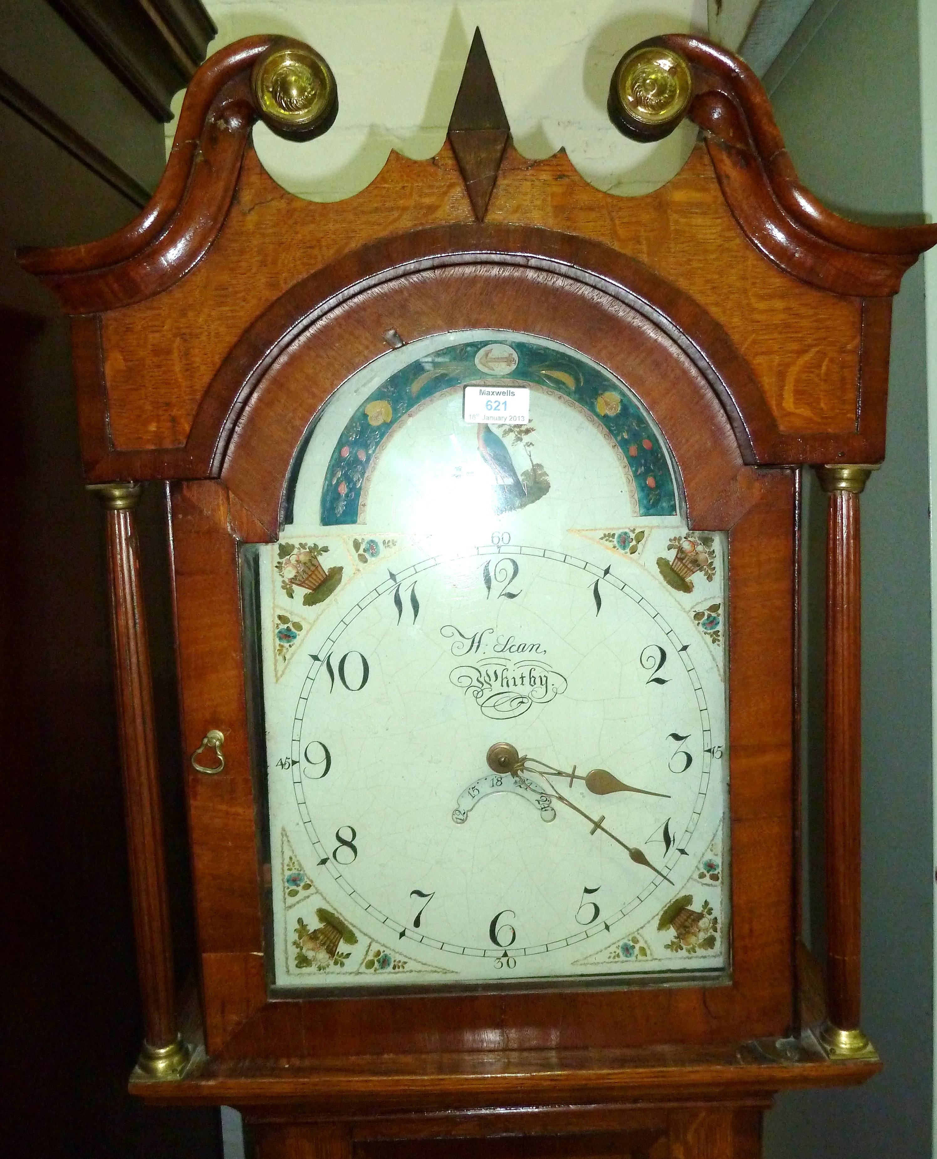 An early 19th century cross-banded oak longcase clock with swan neck pediment and turned reeded side