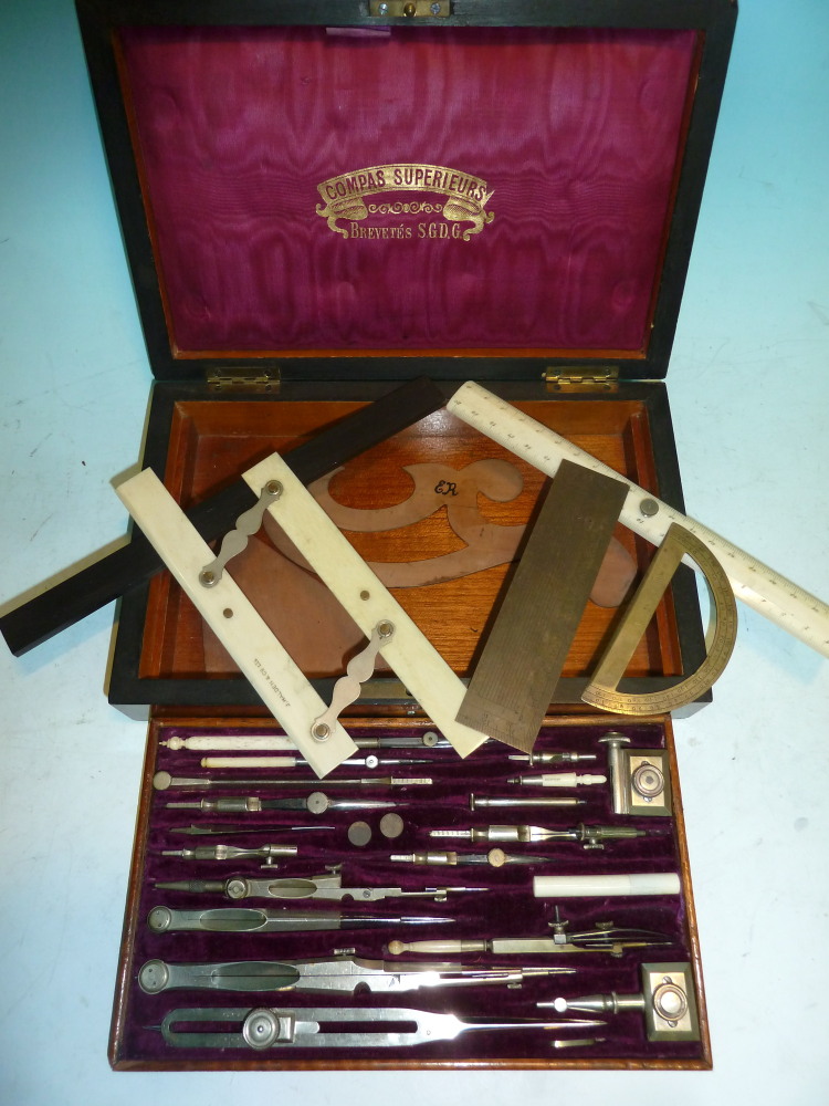 A set of late 19th century French drawing instruments contained in a brass inlaid rosewood box,