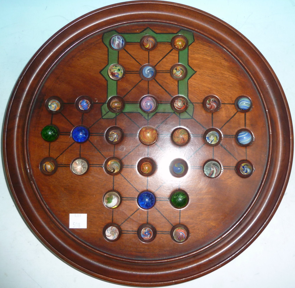 A Victorian mahogany solitaire board with 19th century spiral twist and mica marbles of various
