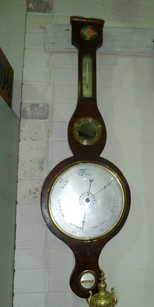 An early 19th century mercury column barometer in banjo shaped figured mahogany case with