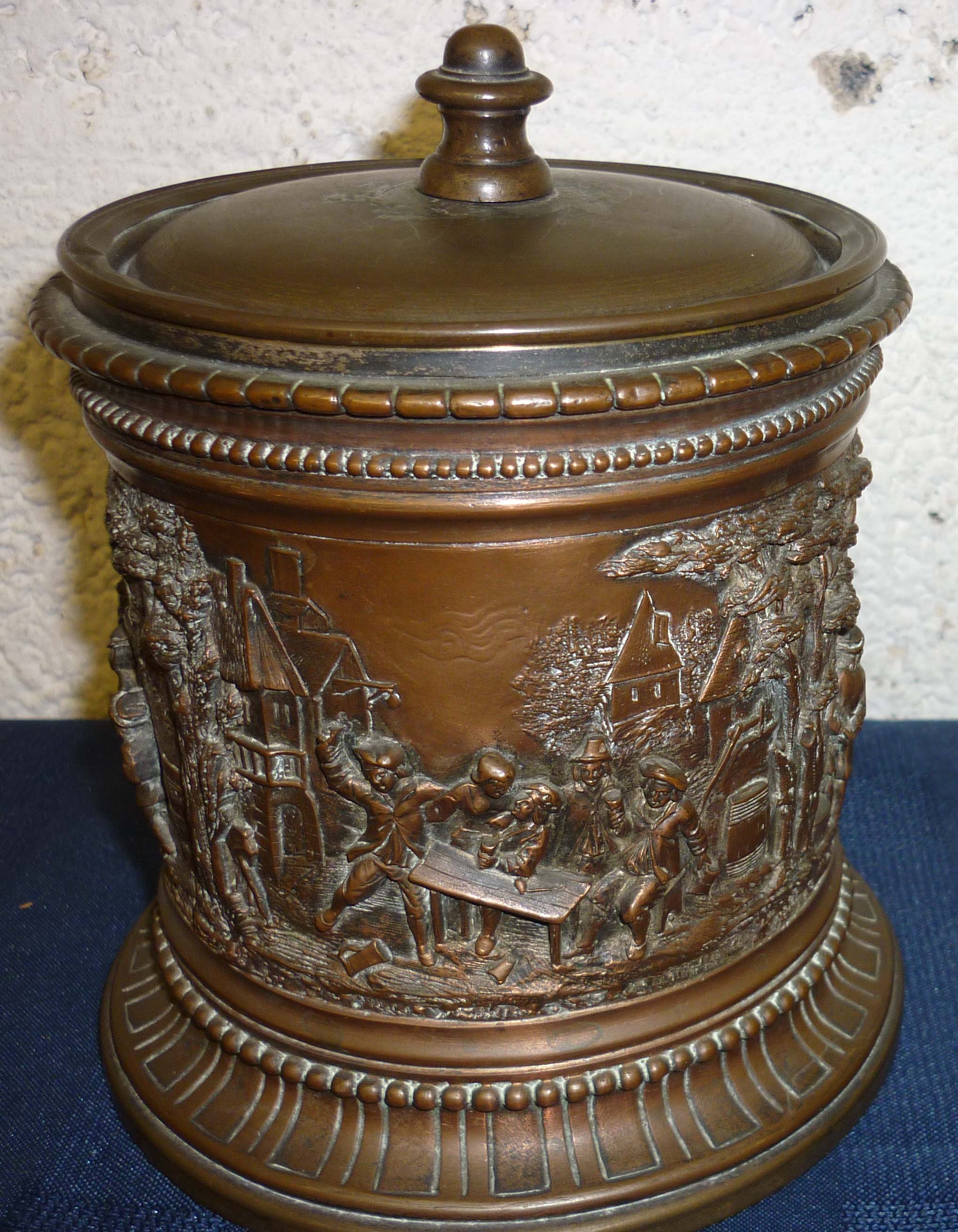 A.B Paris 6” high metal tobacco jar with raised relief copper decoration to body of drinking and