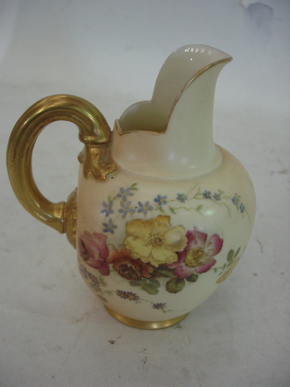 A Royal Worcester blush jug, painted with flower sprays in colours and gilded. 5" high