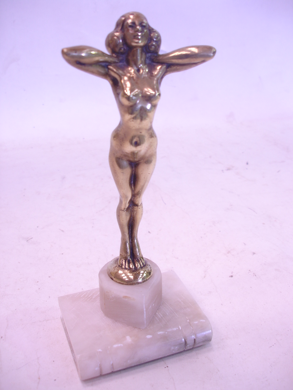 A brass figural car mascot, now mounted on a marble plinth, 8" high