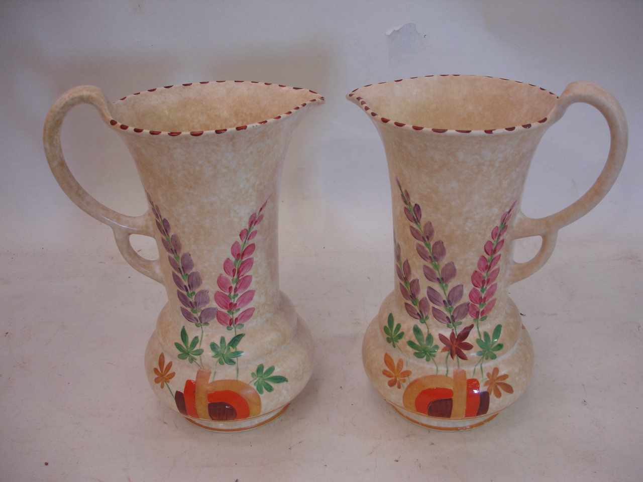 A pair of Roskyl Art Deco jugs, painted in colours, 11" high