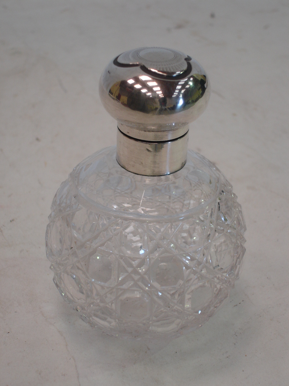 A cut glass silver topped scent bottle, Birmingham 1920. 4 ½" high (No stopper)