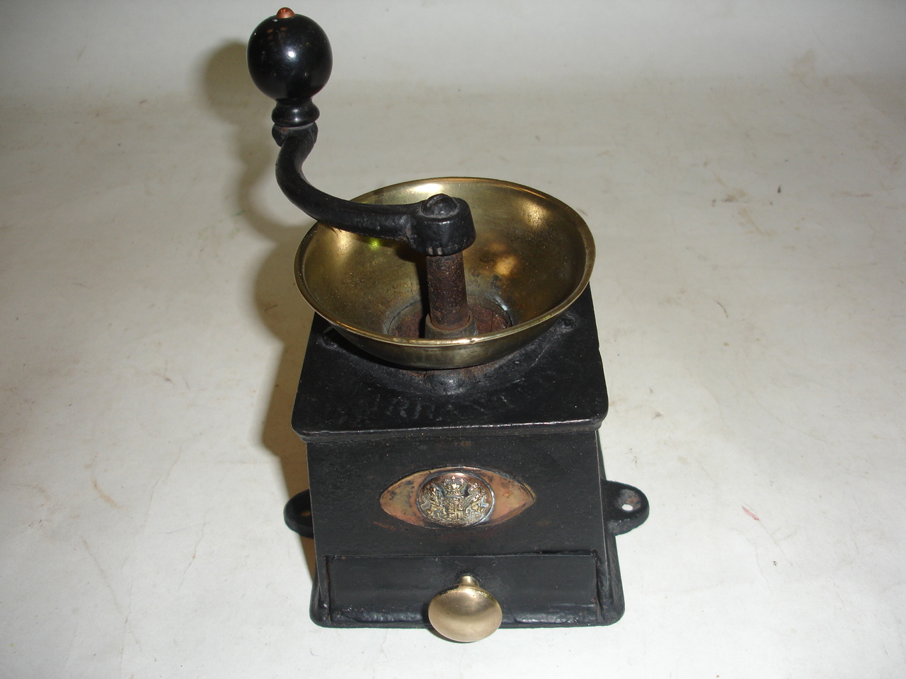 A cast iron and brass coffee grinder