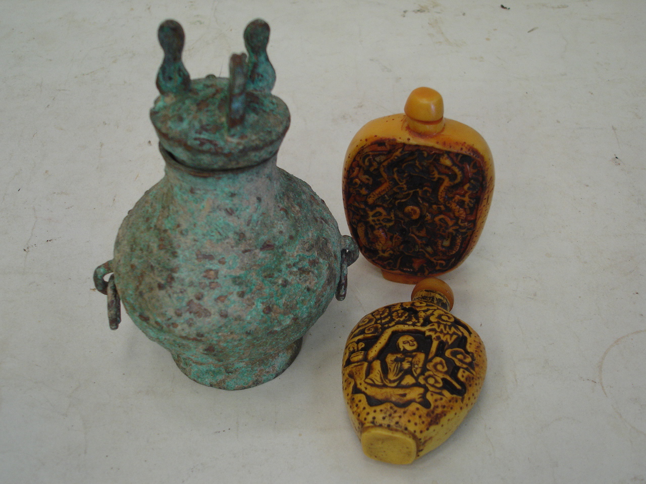 An oriental metal vessel with cover 4 1/4" high and two resin snuff bottles