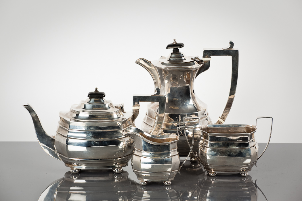 GEORGE V SILVER FOUR PIECE TEA SERVICE comprising a teapot, hot water pot, sugar and cream, of