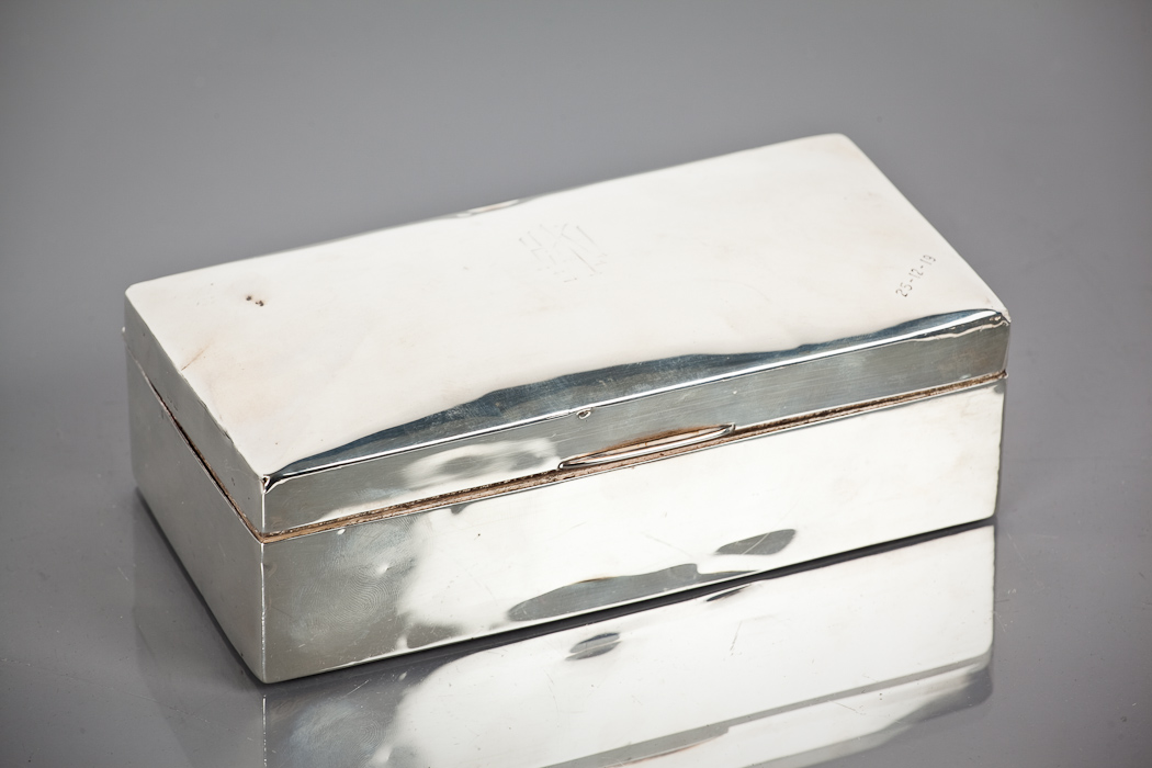 SILVER CIGARETTE BOX of rectangular form, the lid with engraved monogramme, 18cm long Dented and