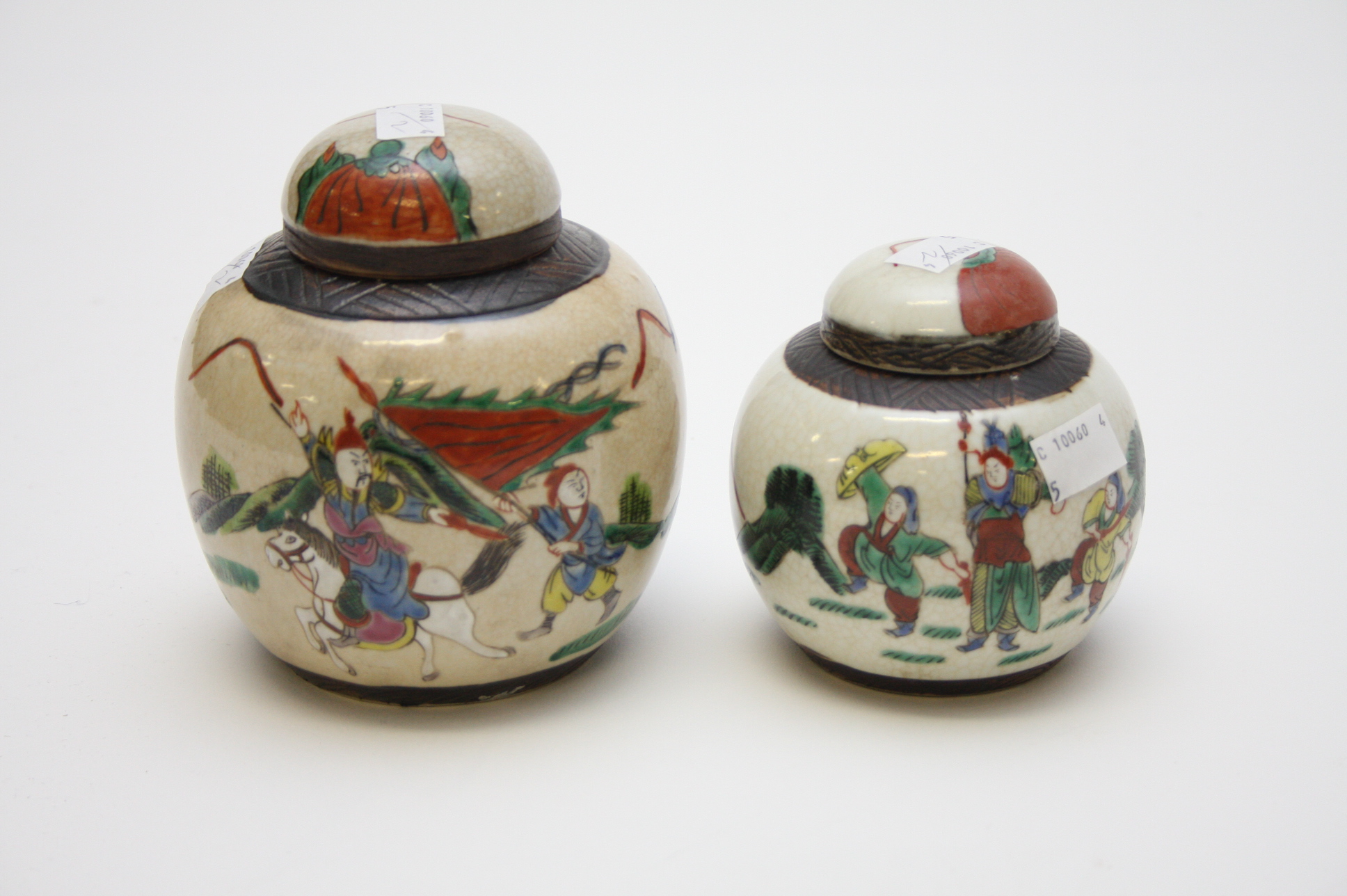 TWO SIMILAR CHINESE CRACKLEWARE GINGER JARS AND COVERS, 
decorated with warriors, one  5.5in (14cm),