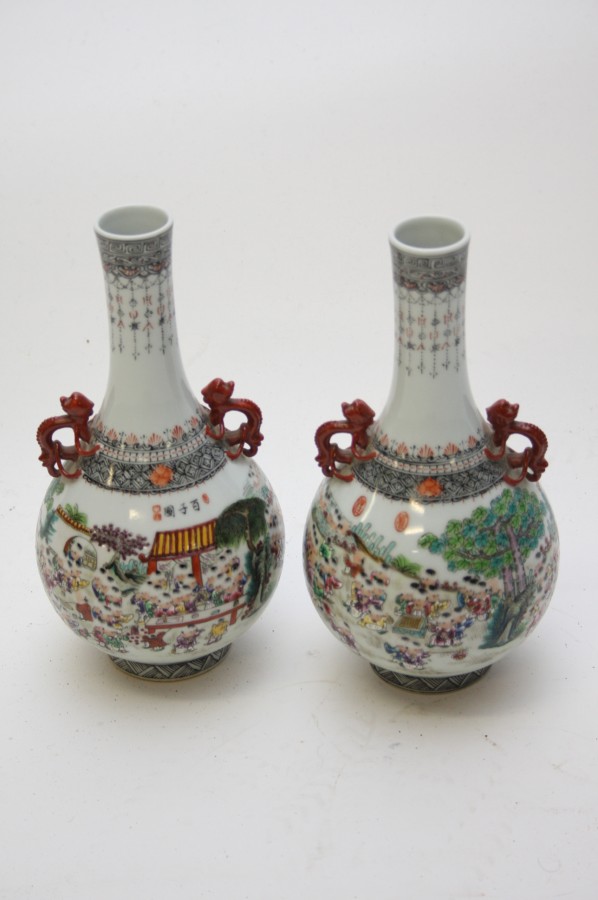 A PAIR OF CHINESE FAMILLE ROSE BOTTLE VASES, 
each decorated with numerous figures, at recreation,