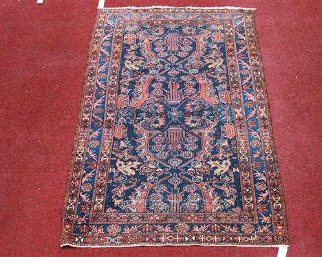 A SEMI ANTIQUE PERSIAN RUG,
from the Lillian region, with five medallions
on an iron red and navy