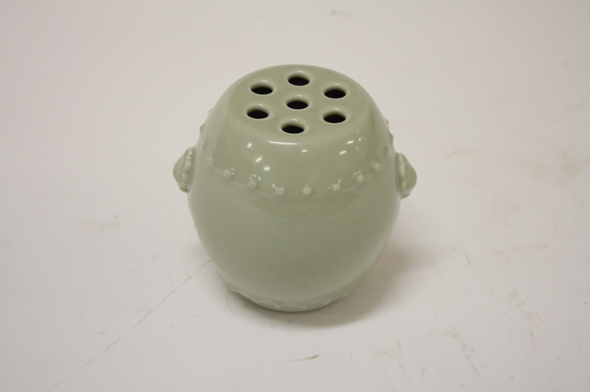 A CHINESE CELADON GROUND BARREL SHAPED BRUSH POT, 
with two shell and ring handles, under perforated