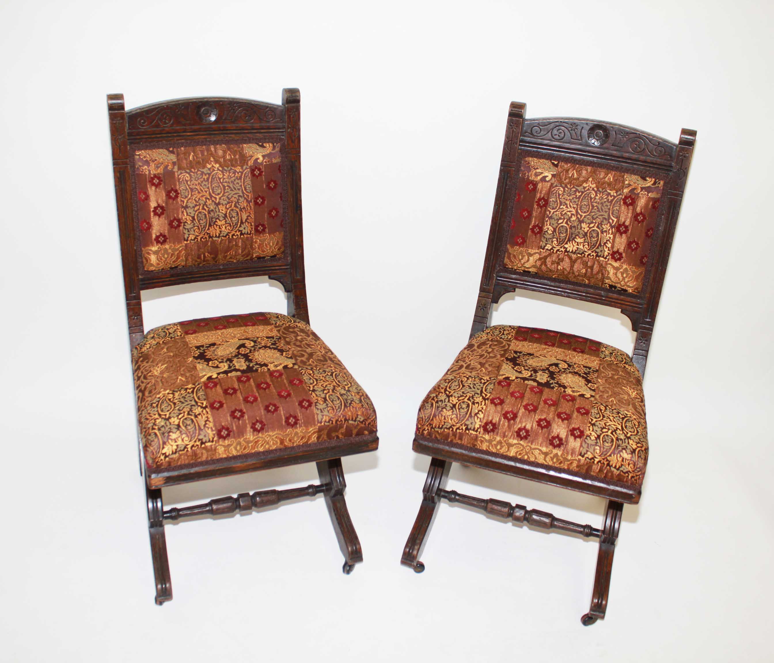 A Set of Eight Unusual Edwardian Carved Oak Side Chairs,
each with a padded back and seat and raised