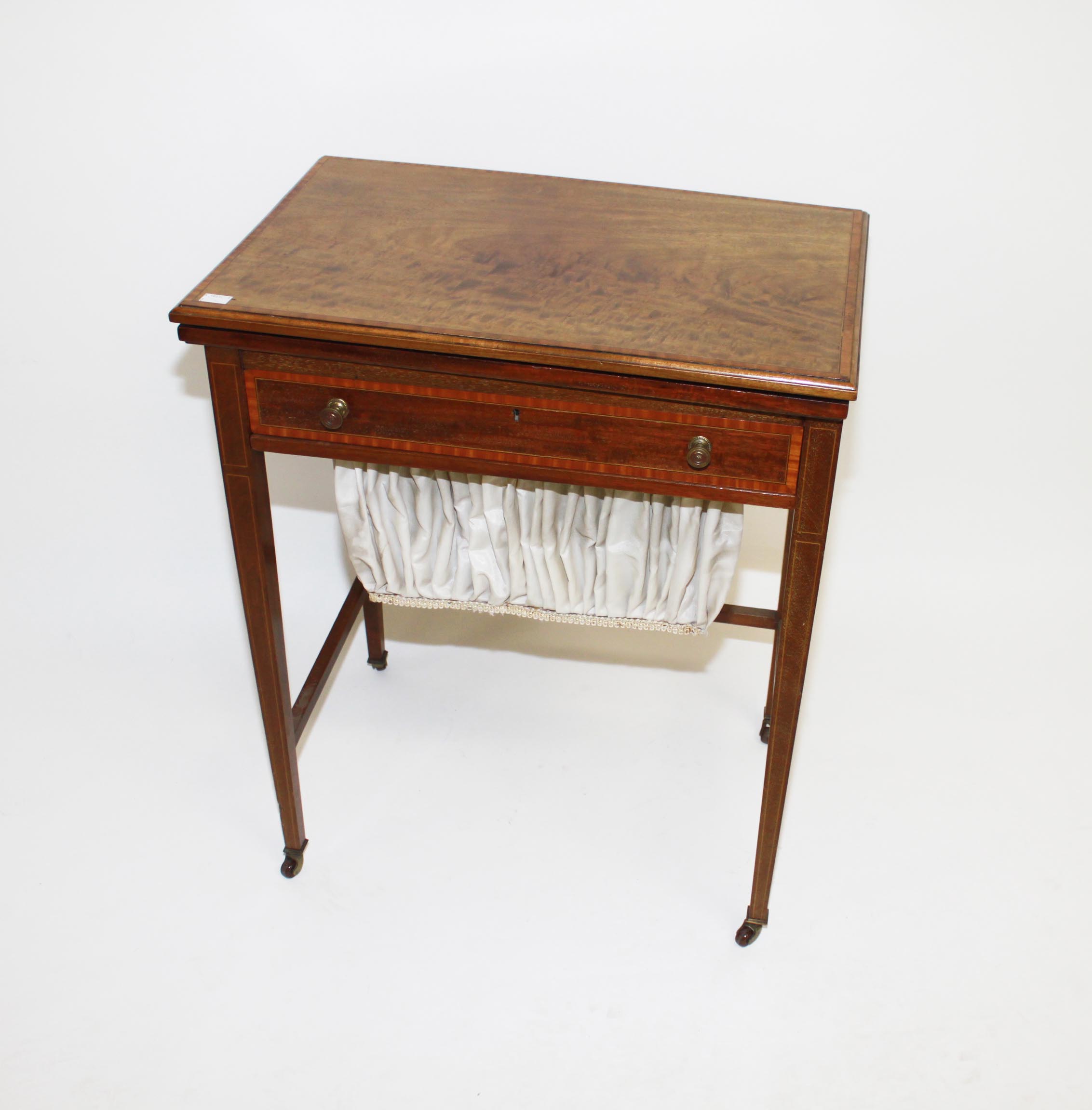 AN EDWARDIAN SATINWOOD BANDED MAHOGANY LADIES WORK OR CARD TABLE,
the foldover moulded top, with a