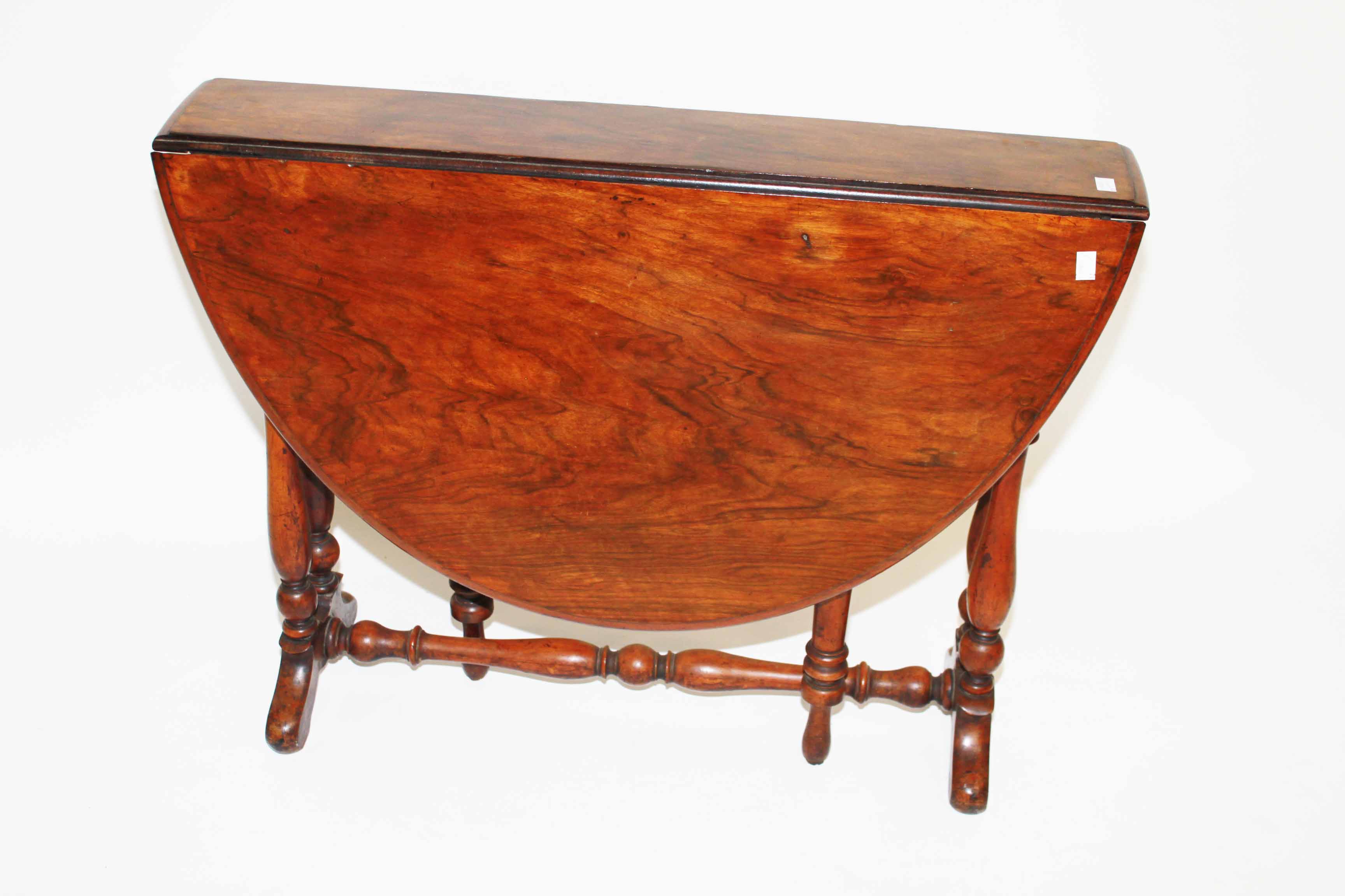 A VICTORIAN WALNUT SUTHERLAND TABLE, 
with demi lune flaps, raised on baluster supports, 35in (