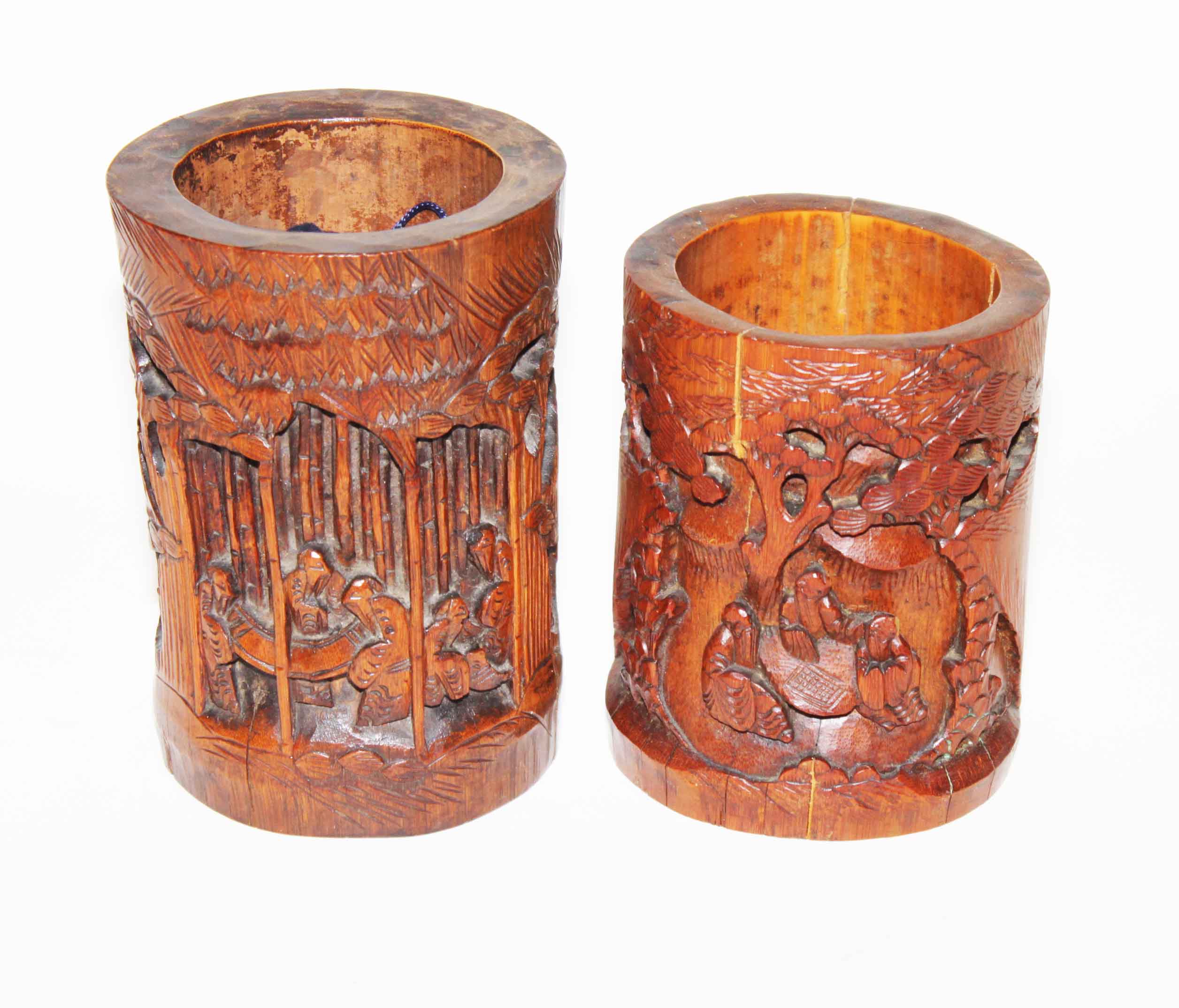 TWO SIMILAR CARVED CHINESE BAMBOO BRUSH POTS, 
depicting figures amongst trees, the tallest, 7.