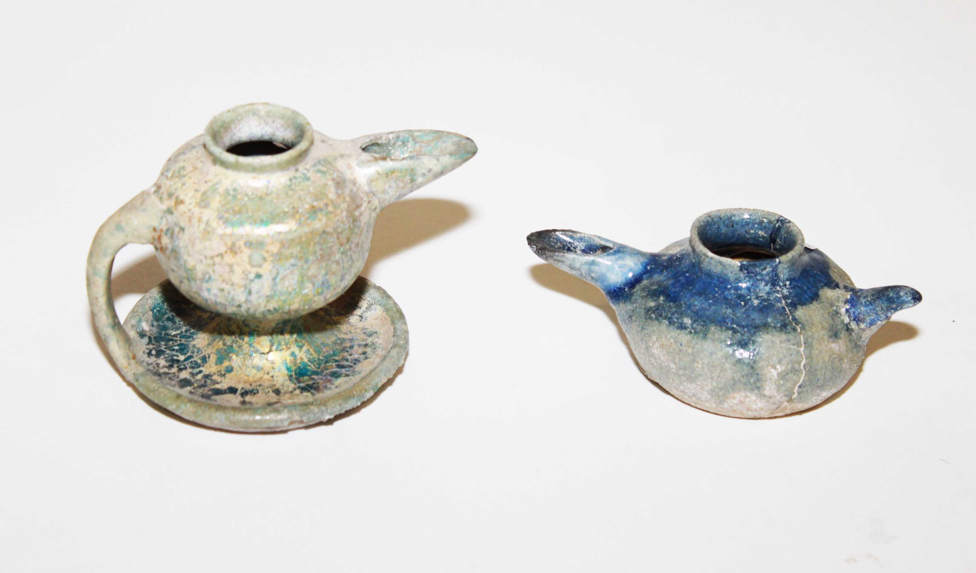 A SMALL PERSIAN EARTHENWARE LAMP, 
with spout and handle, and another larger similar ditto, both