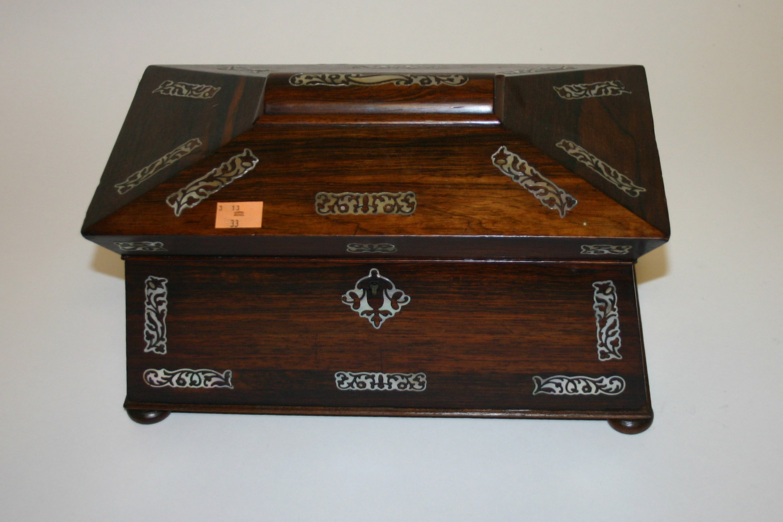 A WILLIAM IV MOTHER O’ PEARL INLAID ROSEWOOD TEACADDY, of sarcophagus form, the hinged cover