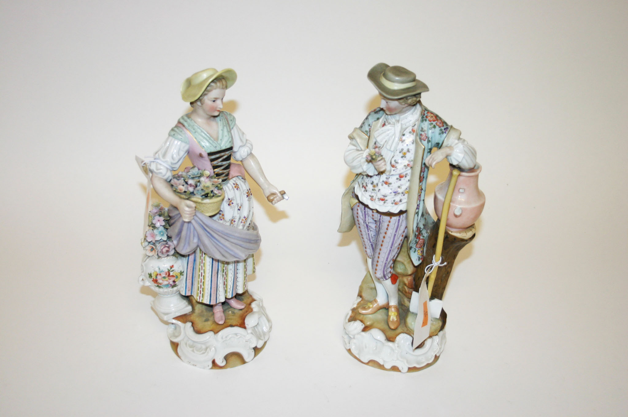 A PAIR OF GERMAN PORCELAIN FIGURES, early 20th century, one modelled as a lady with basket of