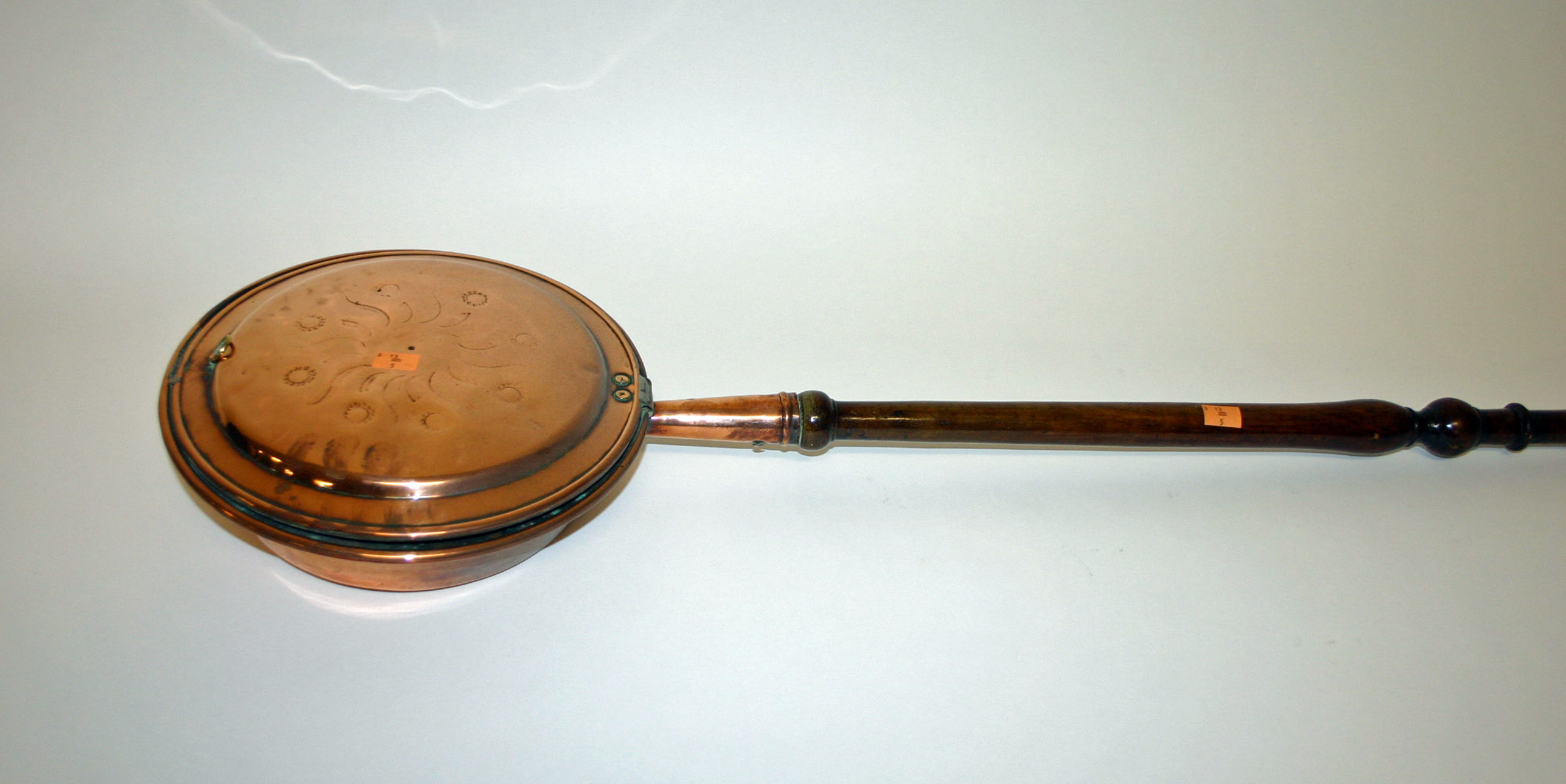 A COPPER BED WARMER, 19th century, with mahogany turned handle. (1)
