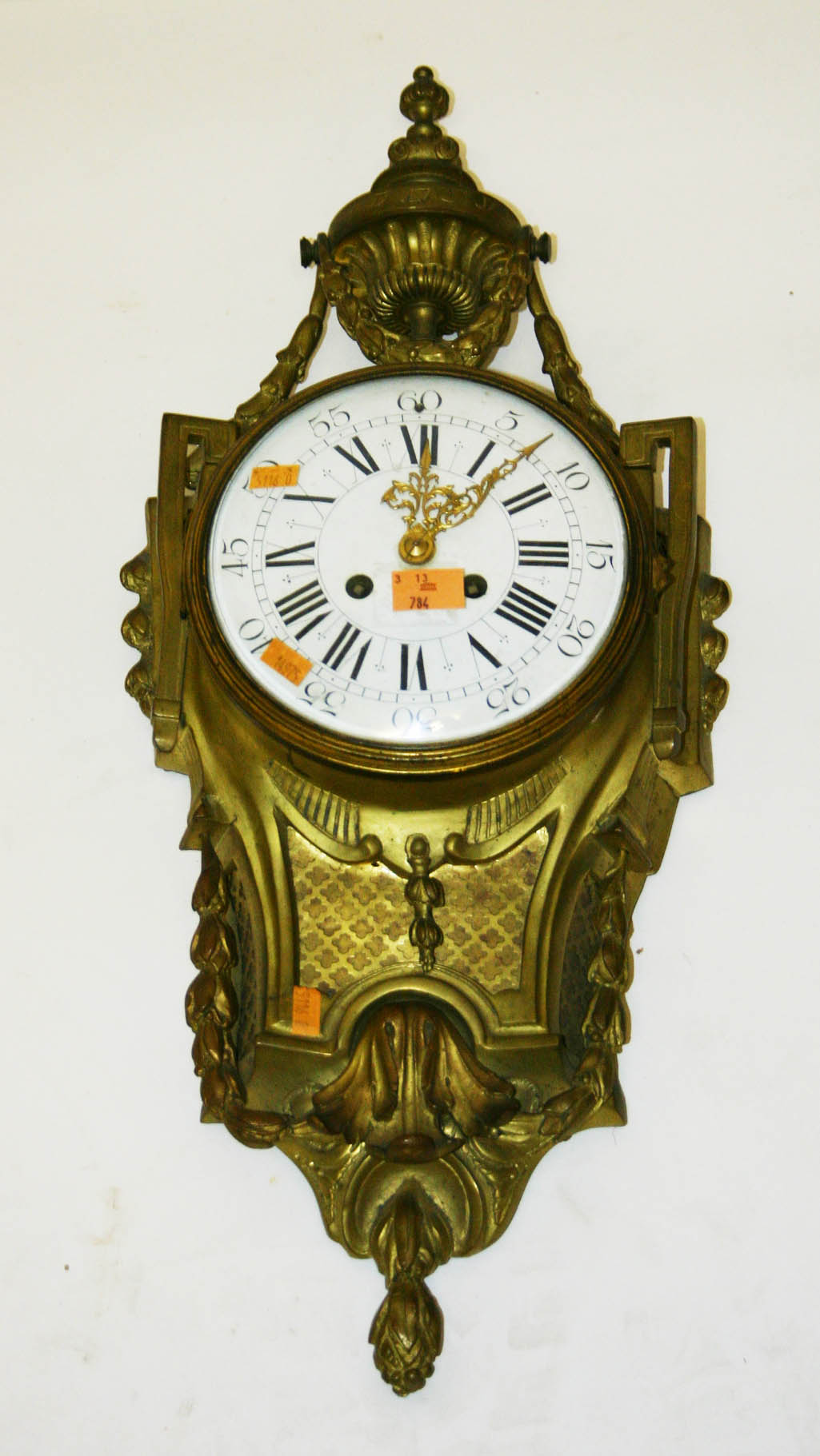 AN ATTRACTIVE FRENCH GILT BRASS CARTEL CLOCK, the urn finial with floral swags above a convex enamel