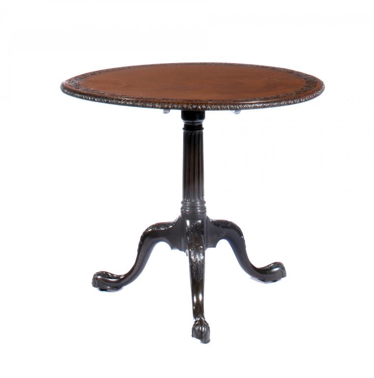 A VICTORIAN MAHOGANY TRIPOD TABLE the figured top with leaf carved border, on fluted pillar and