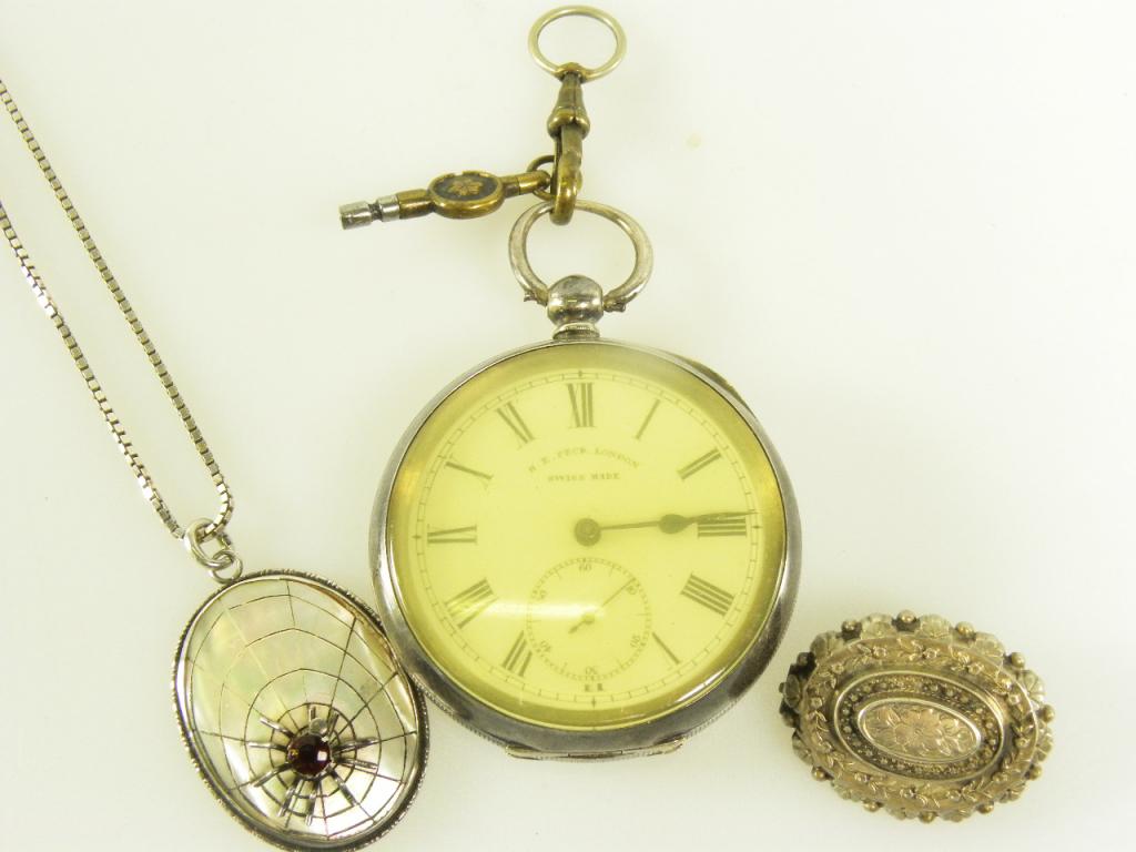 A SILVER LEVER WATCH C1900, A SILVER BROOCH, A SILVER AND MOTHER OF PEARL SPIDER AND WEB LOCKET