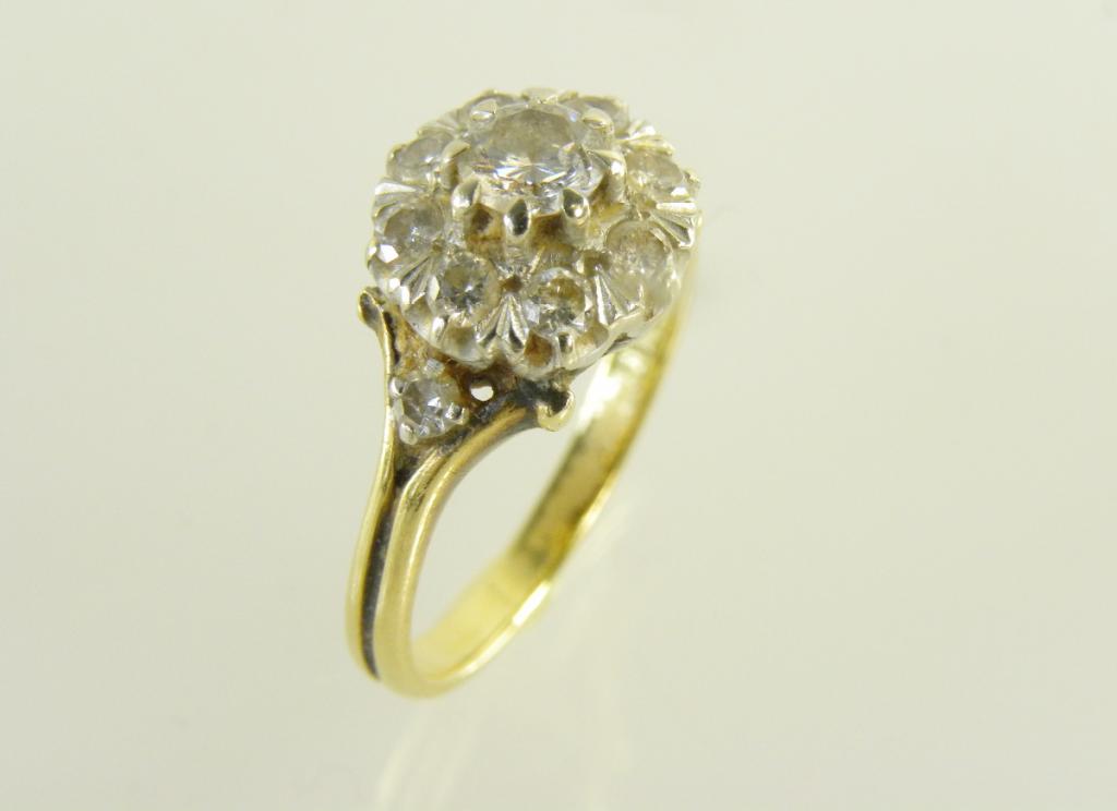 A DIAMOND CLUSTER RING IN GOLD MARKED 18CT