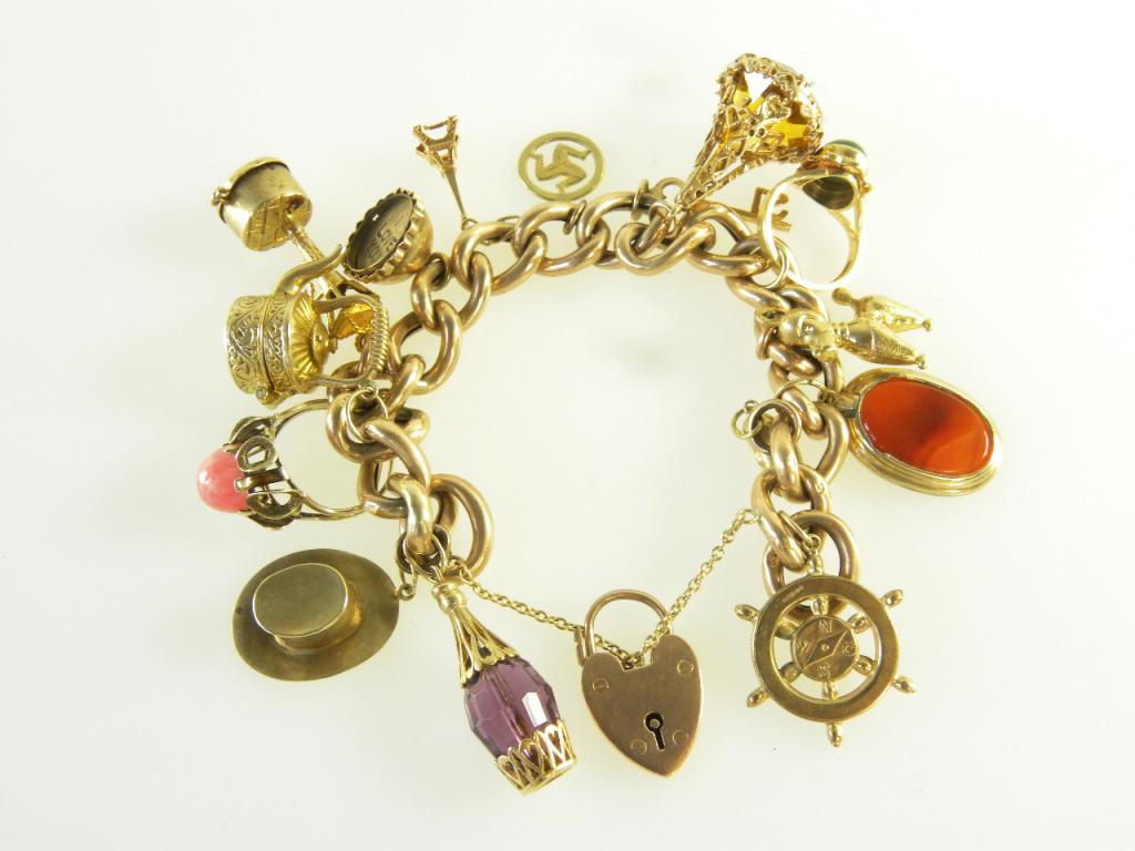 A GOLD CHARM BRACELET MOUNTED WITH A COLLECTION OF GOLD CHARMS, 75G GROSS