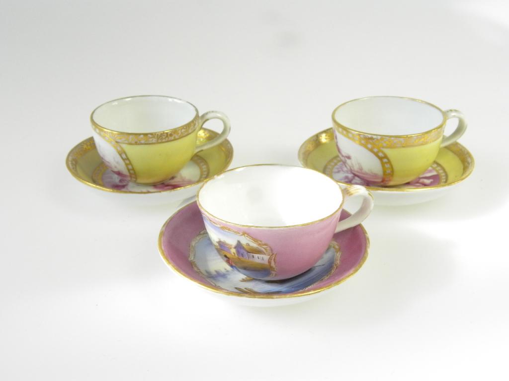 TWO MEISSEN MINIATURE YELLOW GROUND TEACUPS AND SAUCERS, PAINTED EN PUCE CAMAIEU WITH PUTTI AND