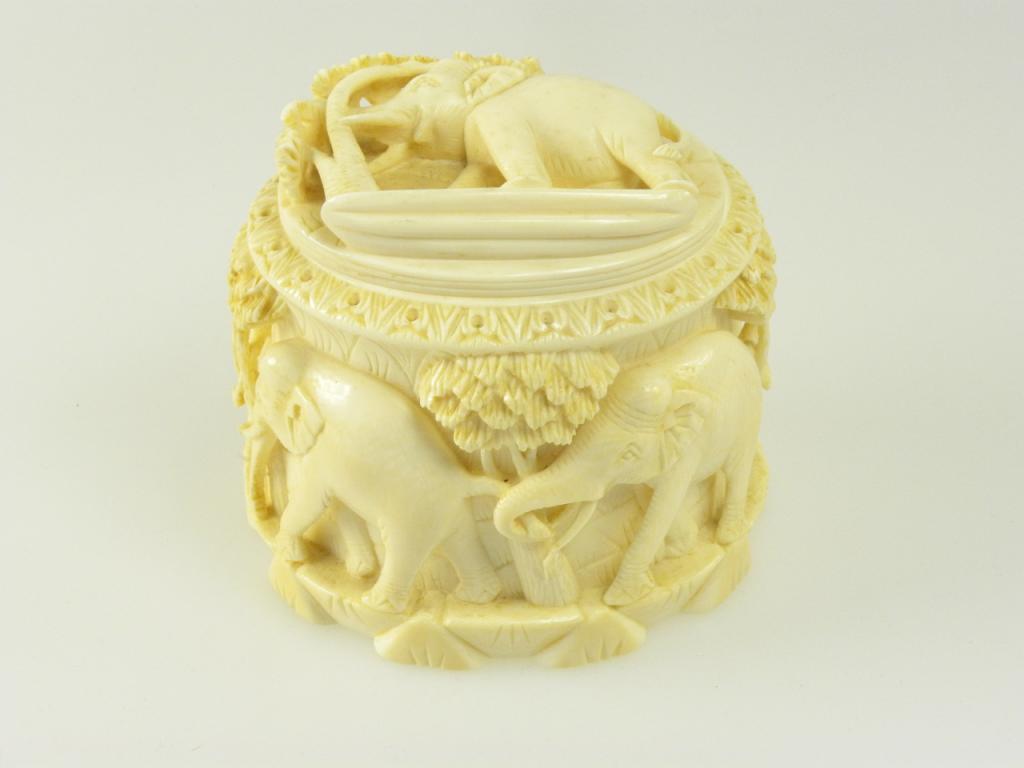 AN INDIAN IVORY BOX AND COVER, CARVED FROM A SECTION OF TUSK WITH A PROCESSION OF ELEPHANTS