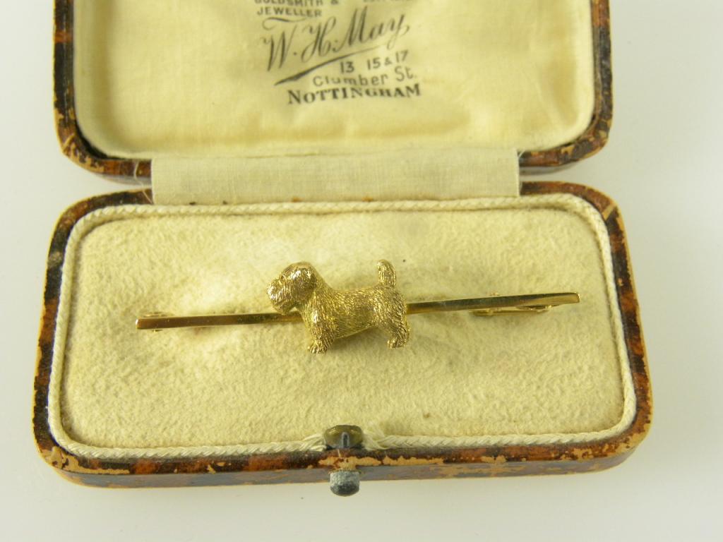 A GOLD TERRIER BAR BROOCH, MARKED 9CT