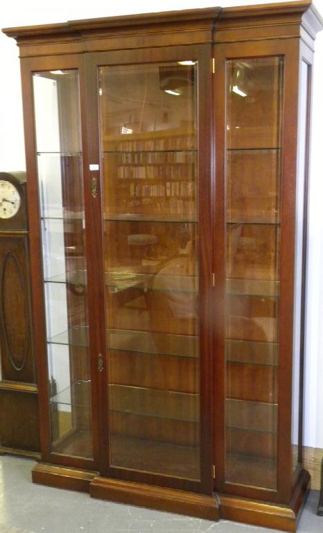 A REPRODUCTION MAHOGANY BREAKFRONT CABINET WITH BEVELLED GLASS LIGHTS TO THE FRONT