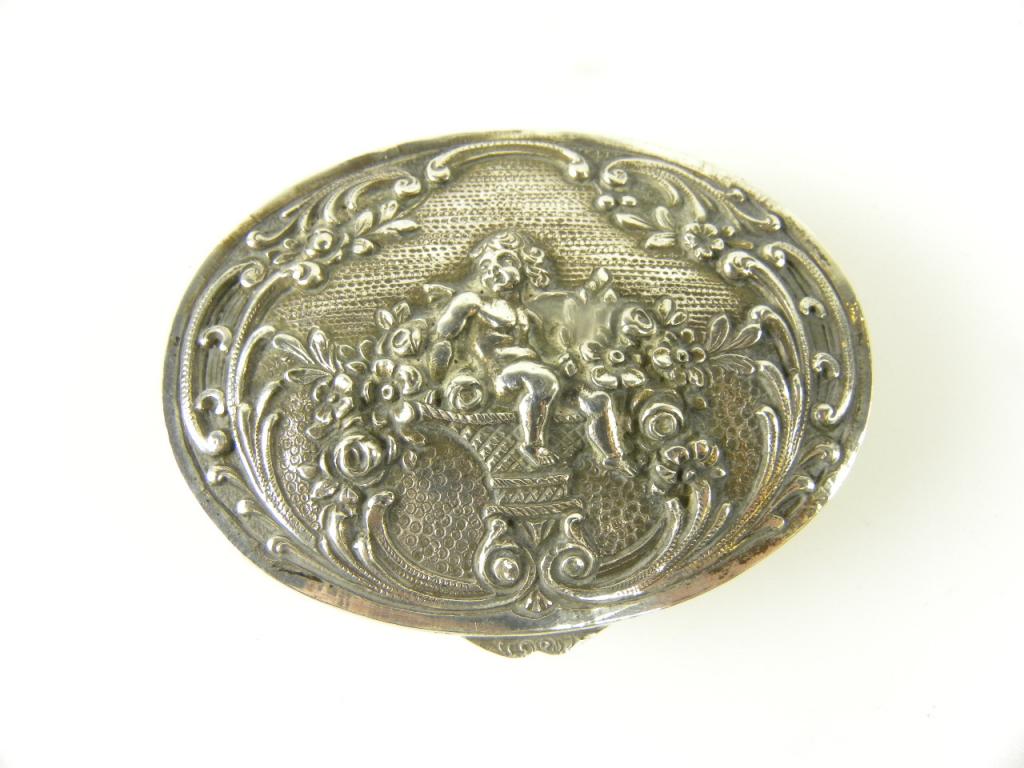 A CONTINENTAL SILVER OVAL SNUFF BOX, THE LID WITH AN ELECTROTYPE PANEL OF PUTTO ON A BASKET OF