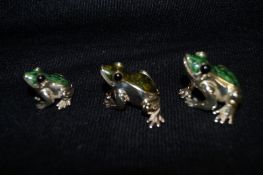 A set of three silver and enamel frog ornaments