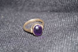 A 9ct gold and oval cabochon amethyst ring