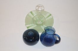 A quantity of glass which includes a blue glass jug, a blue squat vase, a green circular art deco