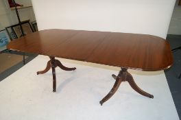 An extending dining table with tripod base on claw and castor feet