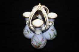 A 19th century Minton & Co. China Posy Basket of Four Baluster Vases Tied by an Over Head Handle,